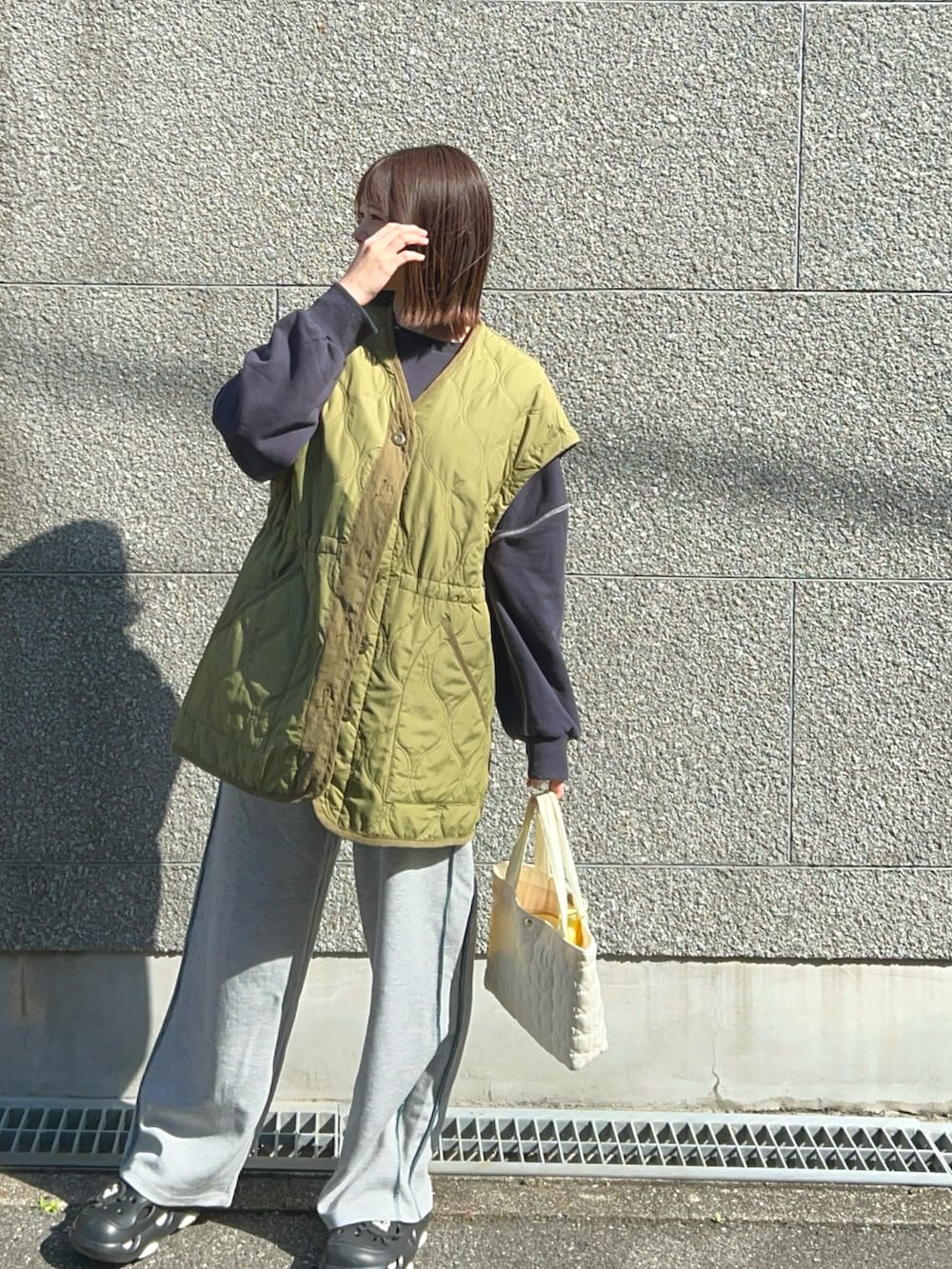 グレー系のスウェットパンツ、ブルー系のスウェット、グリーン系のノーカラージャケットを着用したレディースの春コーディネートの3枚目の写真