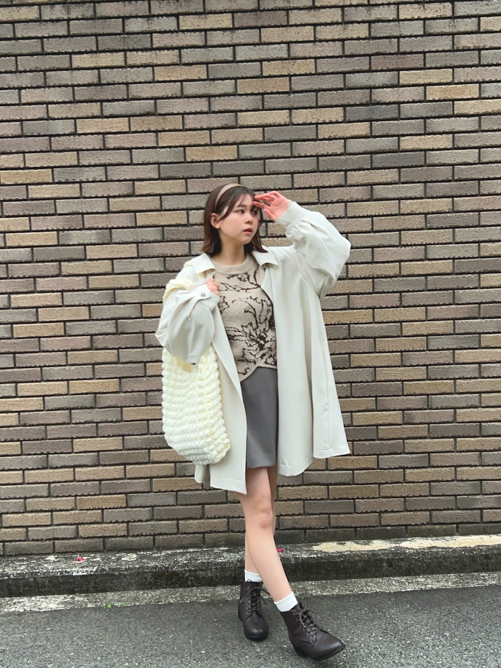 ブラウン系のブーツ、グレー系のスカート、ベージュ系のニット/セーターを着用したレディースの春コーディネートの4枚目の写真