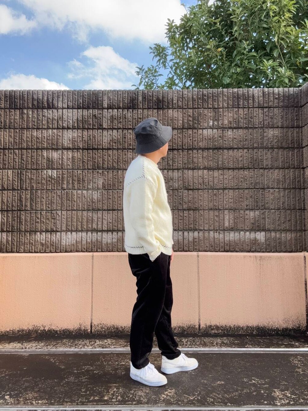 ホワイト系のニット/セーター、ブラック系のその他パンツを着用したメンズの冬コーディネートの2枚目の写真