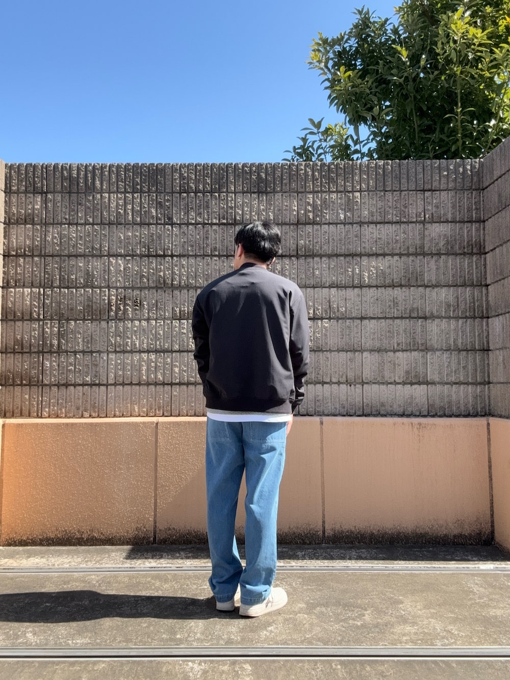 ブラック系のブルゾン、グレー系のTシャツ/カットソー、ブルー系のデニムパンツを着用したメンズの春コーディネートの3枚目の写真