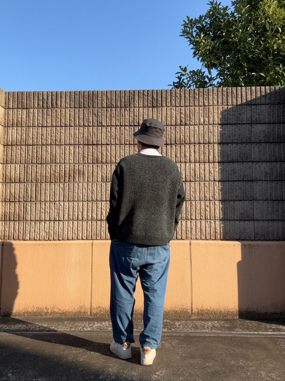 グリーン系のニット/セーター、ブルー系のその他パンツを着用したメンズの冬コーディネートの2枚目の写真