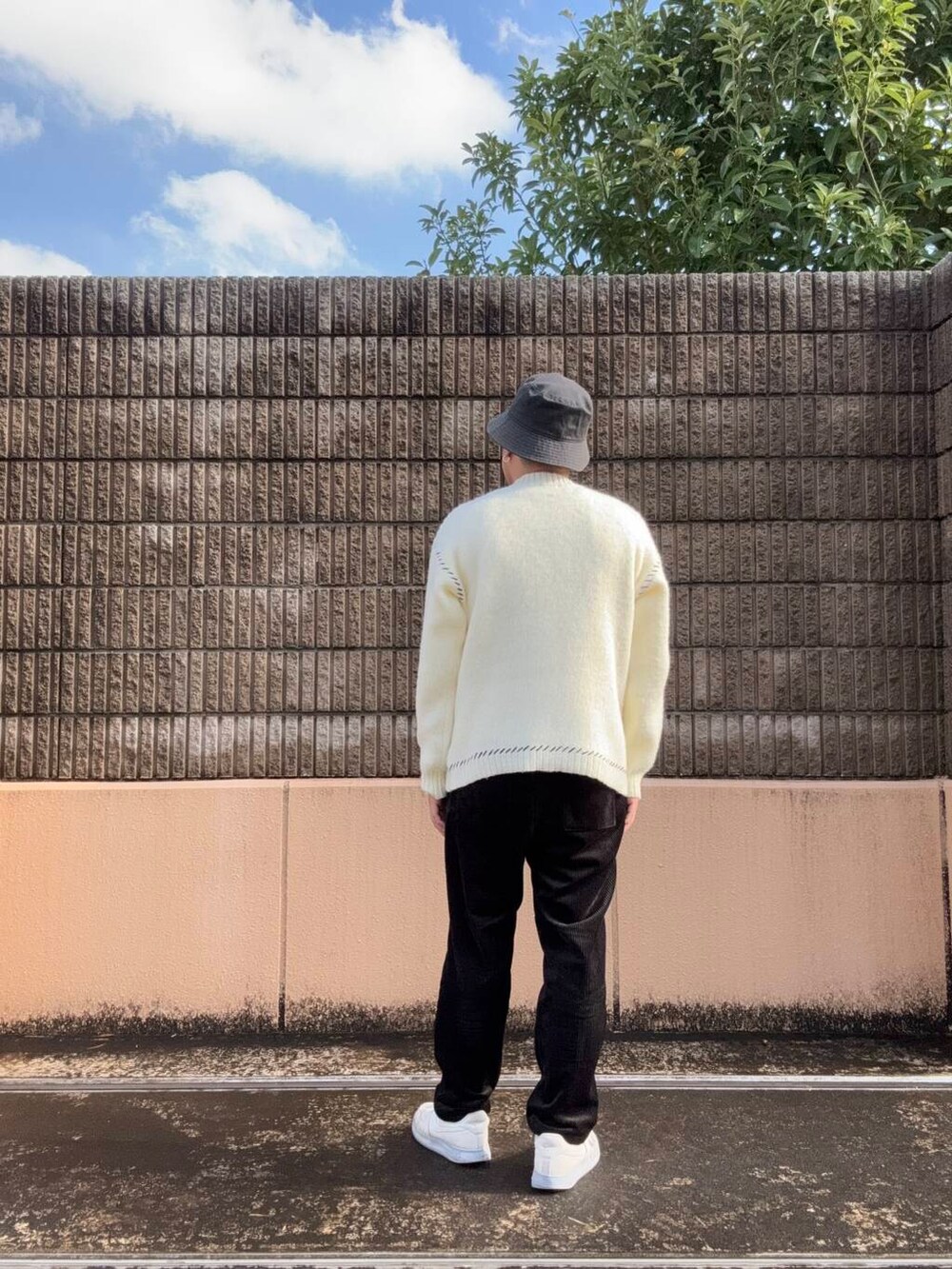 ホワイト系のニット/セーター、ブラック系のその他パンツを着用したメンズの冬コーディネートの3枚目の写真