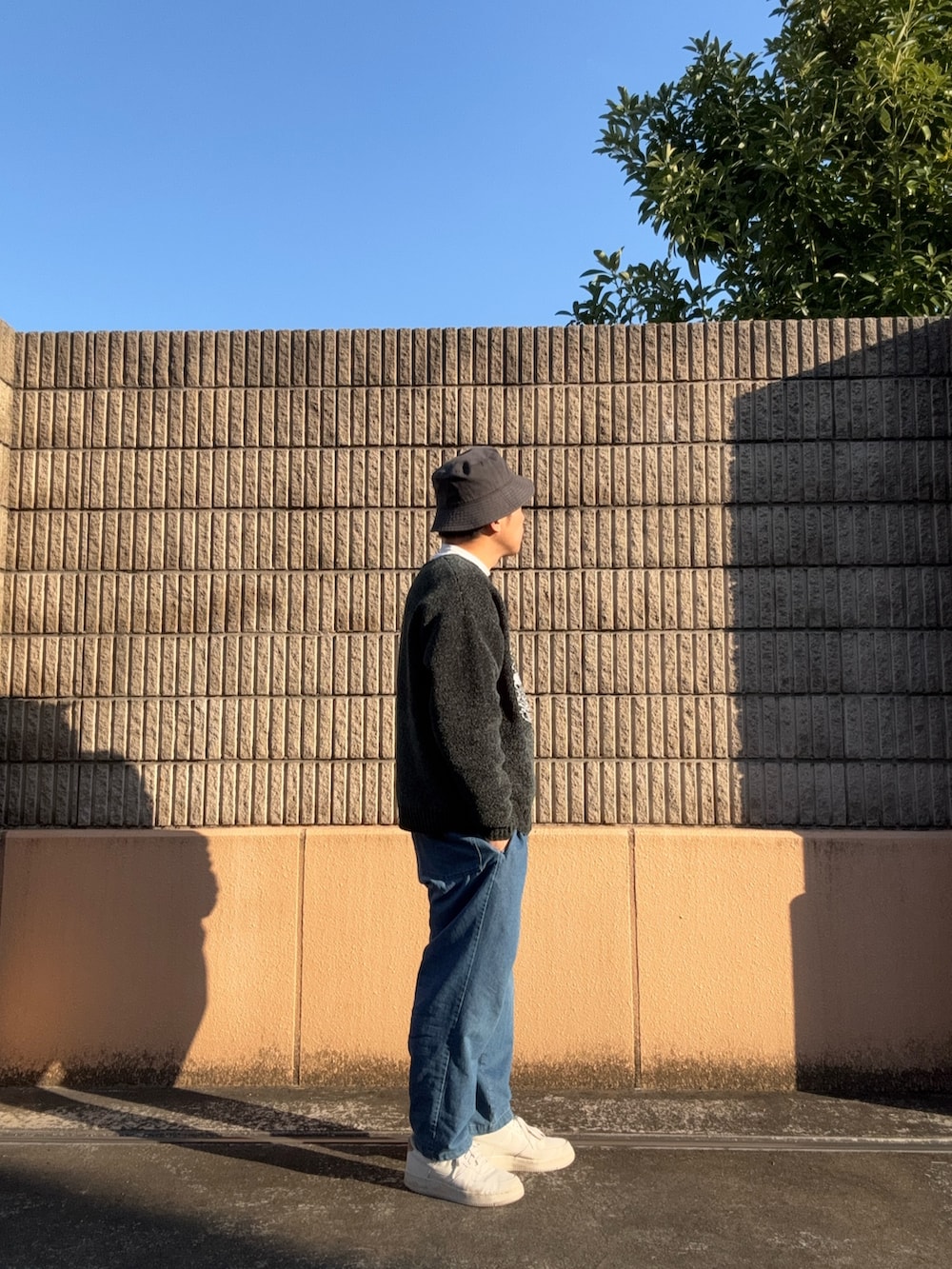 グリーン系のニット/セーター、ブルー系のその他パンツを着用したメンズの冬コーディネートの3枚目の写真