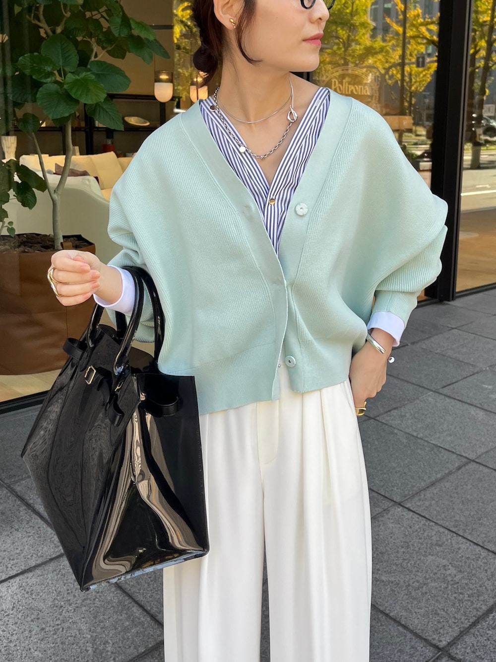 ホワイト系のカーディガン/ボレロ、ホワイト系のスラックスを着用したレディースの冬コーディネートの2枚目の写真