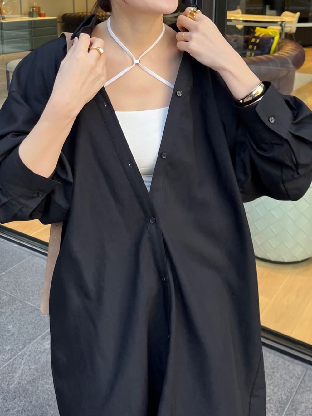 ブラック系のワンピース、ブルー系のデニムパンツ、ホワイト系のキャミソールを着用したレディースの冬コーディネートの3枚目の写真