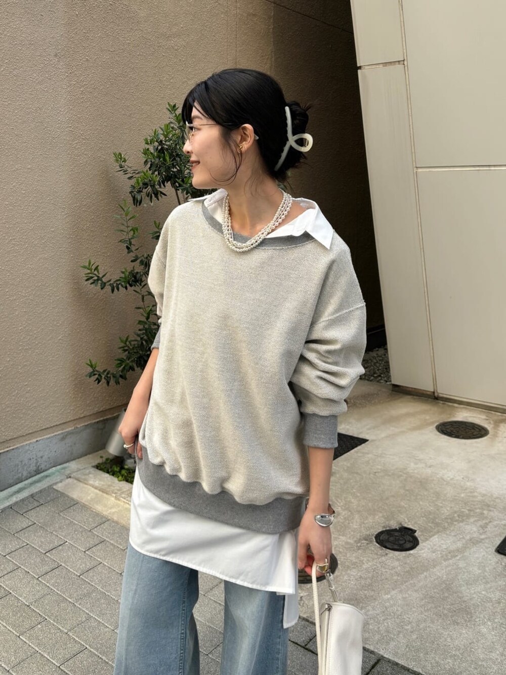 グレー系のTシャツ/カットソー、ホワイト系のシャツ/ブラウス、ブルー系のデニムパンツを着用したレディースの冬コーディネートの3枚目の写真
