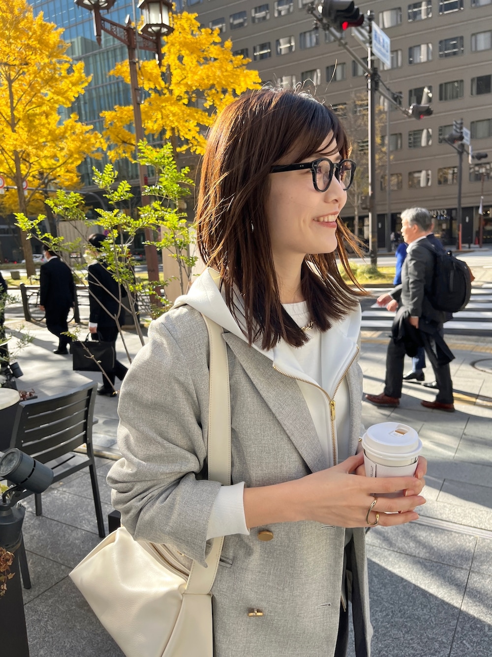 ホワイト系のパーカー、グレー系のテーラードジャケット、グレー系のスカートを着用したレディースの冬コーディネートの7枚目の写真