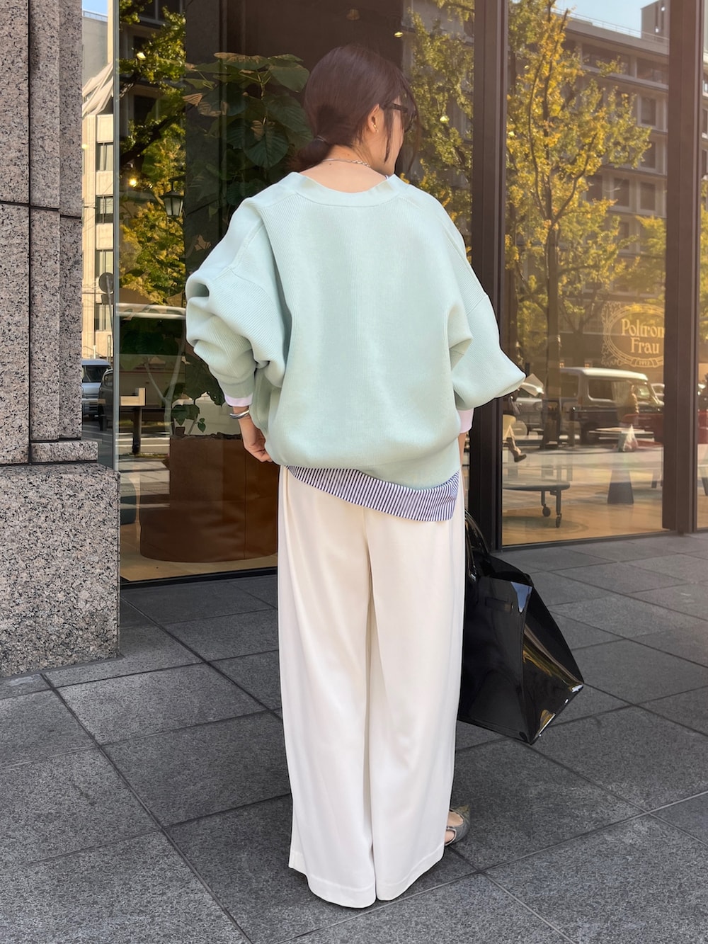 ホワイト系のカーディガン/ボレロ、ホワイト系のスラックスを着用したレディースの冬コーディネートの6枚目の写真