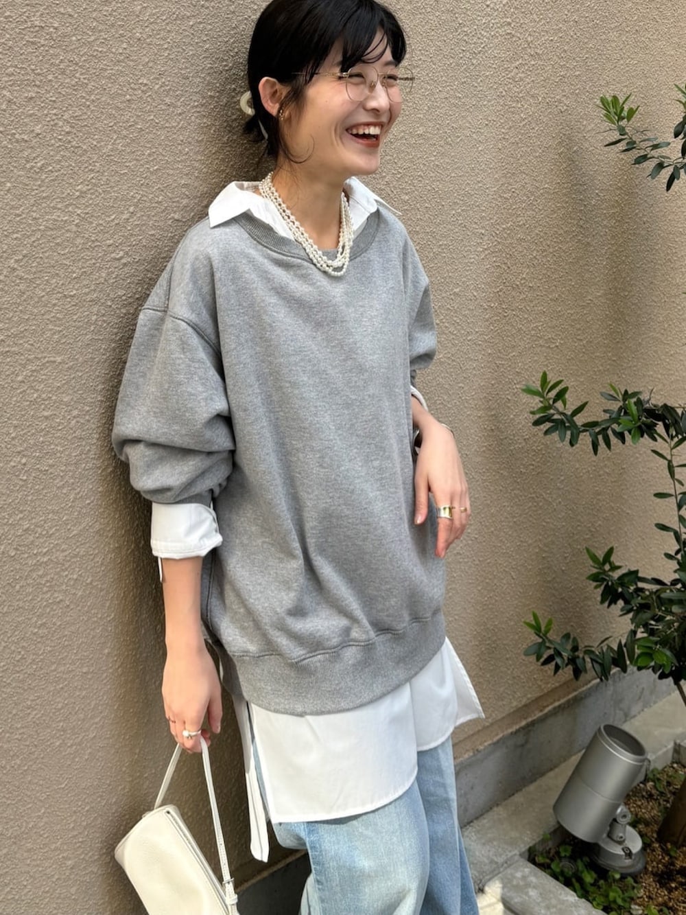 グレー系のTシャツ/カットソー、ホワイト系のシャツ/ブラウス、ブルー系のデニムパンツを着用したレディースの冬コーディネートの5枚目の写真