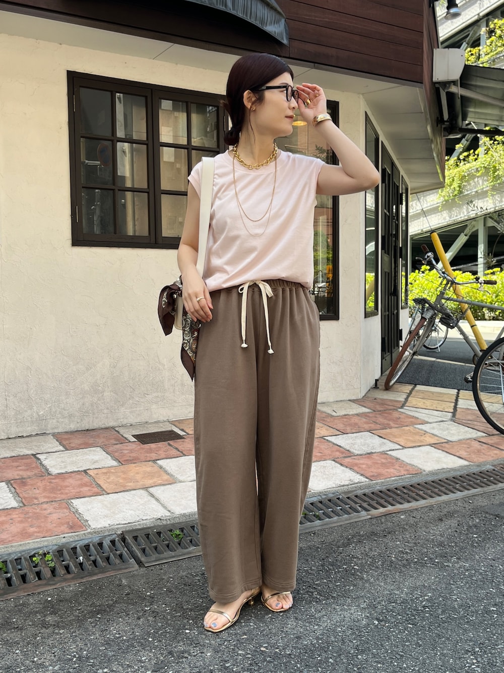 ピンク系のTシャツ/カットソー、ブラウン系のその他パンツ、ホワイト系のショルダーバッグを着用したレディースの春コーディネートの4枚目の写真