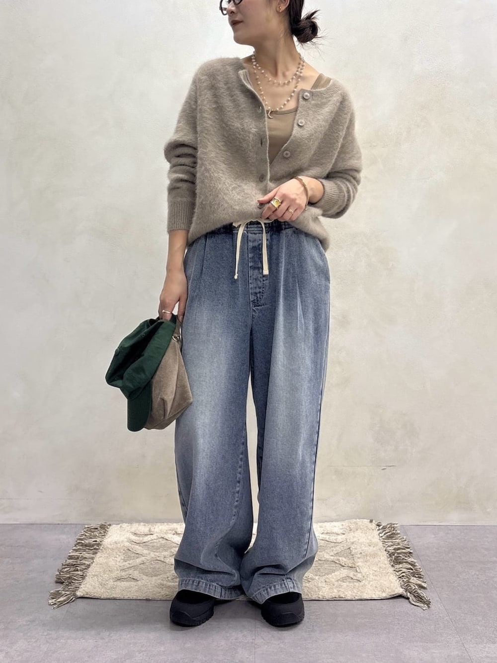 ブラウン系のカーディガン/ボレロ、ブルー系のデニムパンツ、ゴールド系のネックレスを着用したレディースの秋コーディネートの4枚目の写真