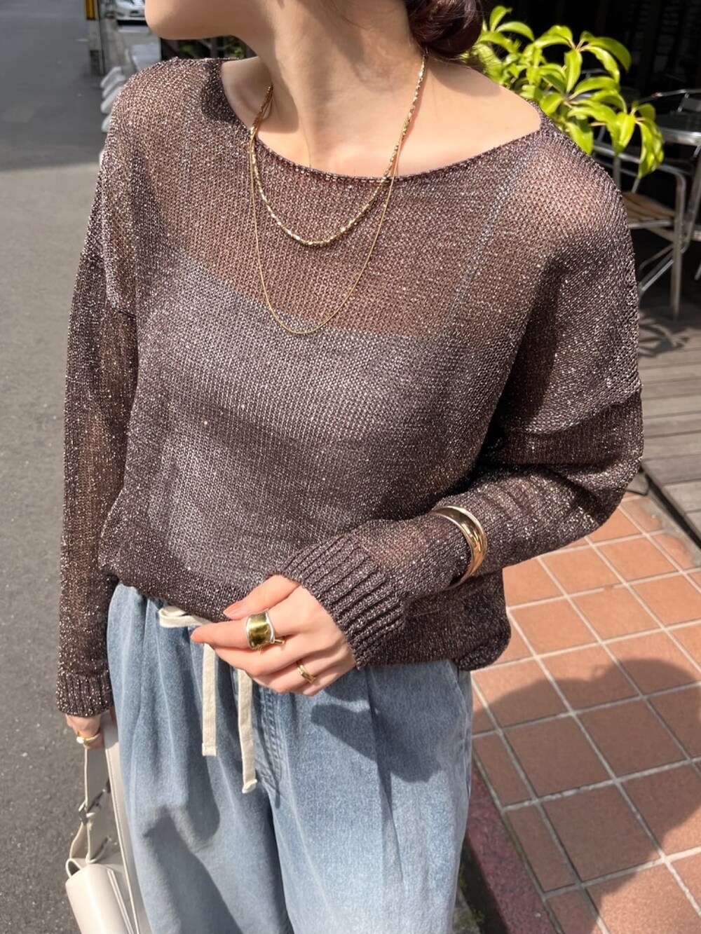 ブラウン系のニット/セーター、ブルー系のデニムパンツ、シルバー系のブーツを着用したレディースの春コーディネートの6枚目の写真