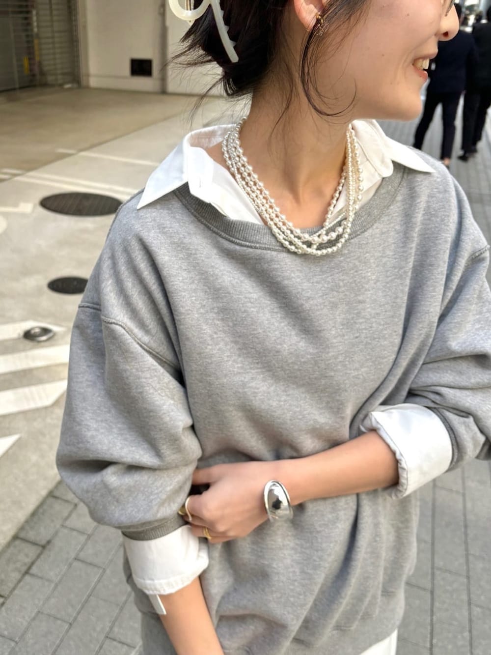 グレー系のTシャツ/カットソー、ホワイト系のシャツ/ブラウス、ブルー系のデニムパンツを着用したレディースの冬コーディネートの6枚目の写真