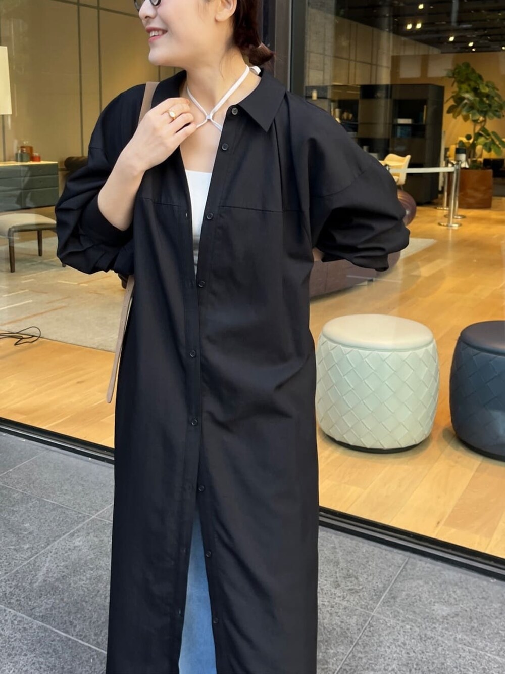 ブラック系のワンピース、ブルー系のデニムパンツ、ホワイト系のキャミソールを着用したレディースの冬コーディネートの2枚目の写真