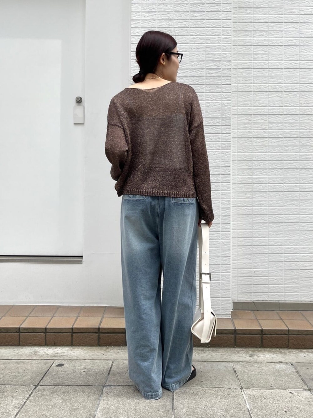 ブラウン系のニット/セーター、ブルー系のデニムパンツ、シルバー系のブーツを着用したレディースの春コーディネートの3枚目の写真