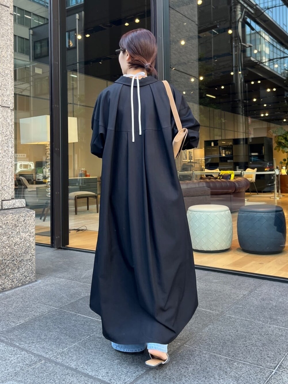 ブラック系のワンピース、ブルー系のデニムパンツ、ホワイト系のキャミソールを着用したレディースの冬コーディネートの5枚目の写真