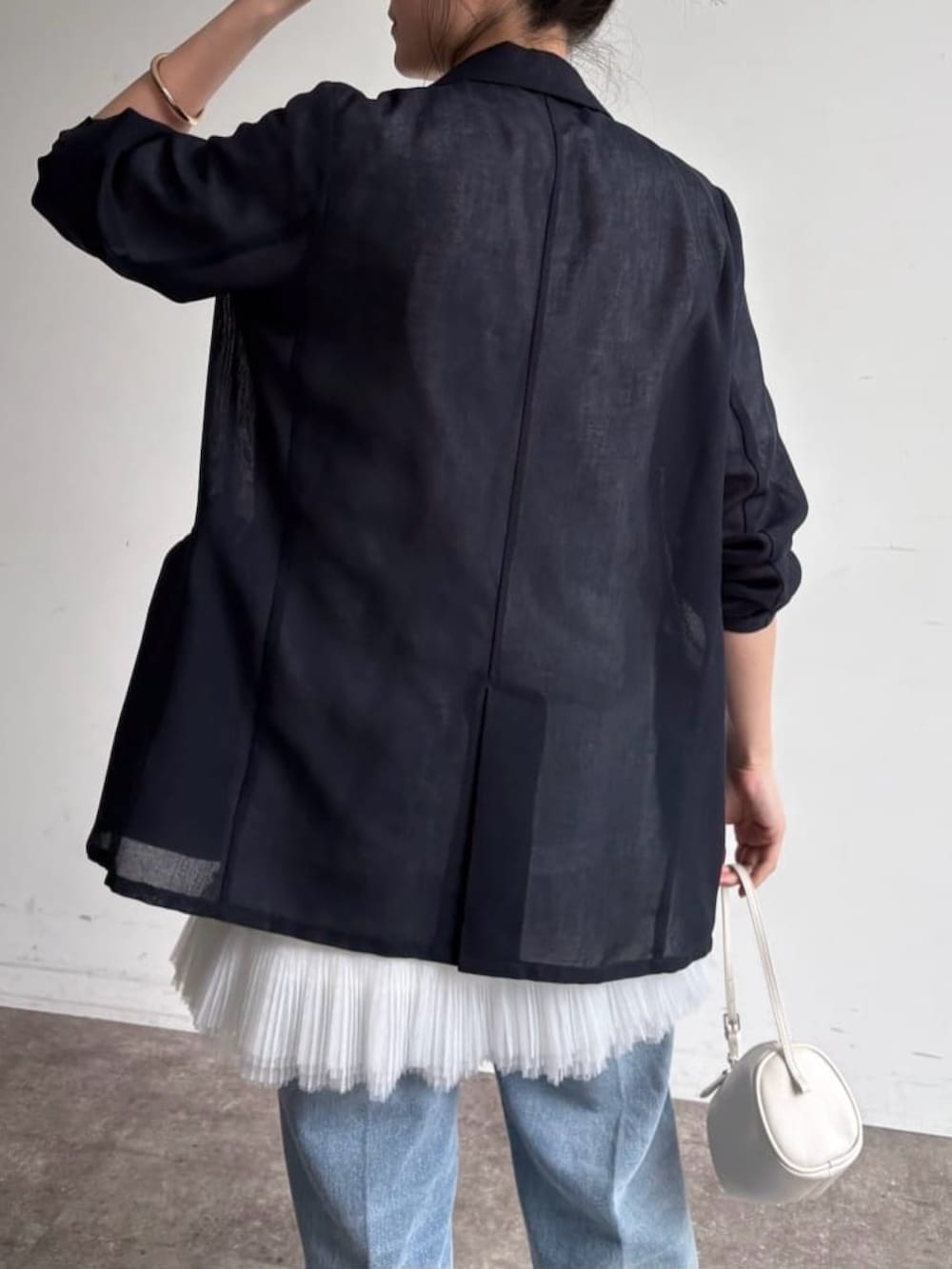 ホワイト系のTシャツ/カットソー、ホワイト系のシャツ/ブラウス、ブルー系のデニムパンツを着用したレディースの春コーディネートの4枚目の写真