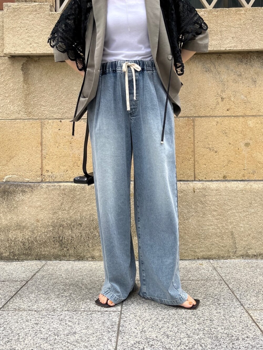 ベージュ系のテーラードジャケット、ブルー系のデニムパンツ、ホワイト系のTシャツ/カットソーを着用したレディースの夏コーディネートの2枚目の写真