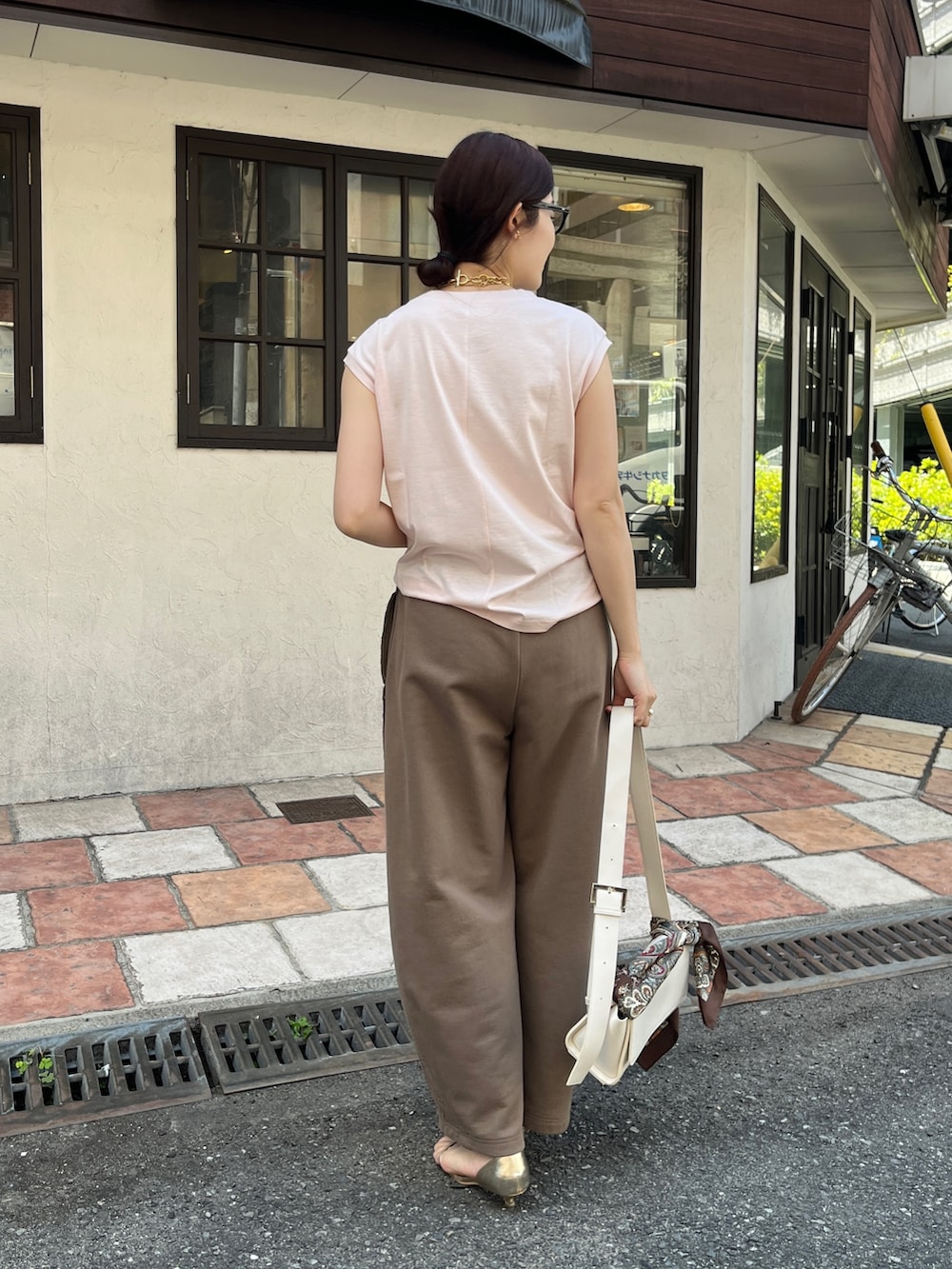 ピンク系のTシャツ/カットソー、ブラウン系のその他パンツ、ホワイト系のショルダーバッグを着用したレディースの春コーディネートの5枚目の写真