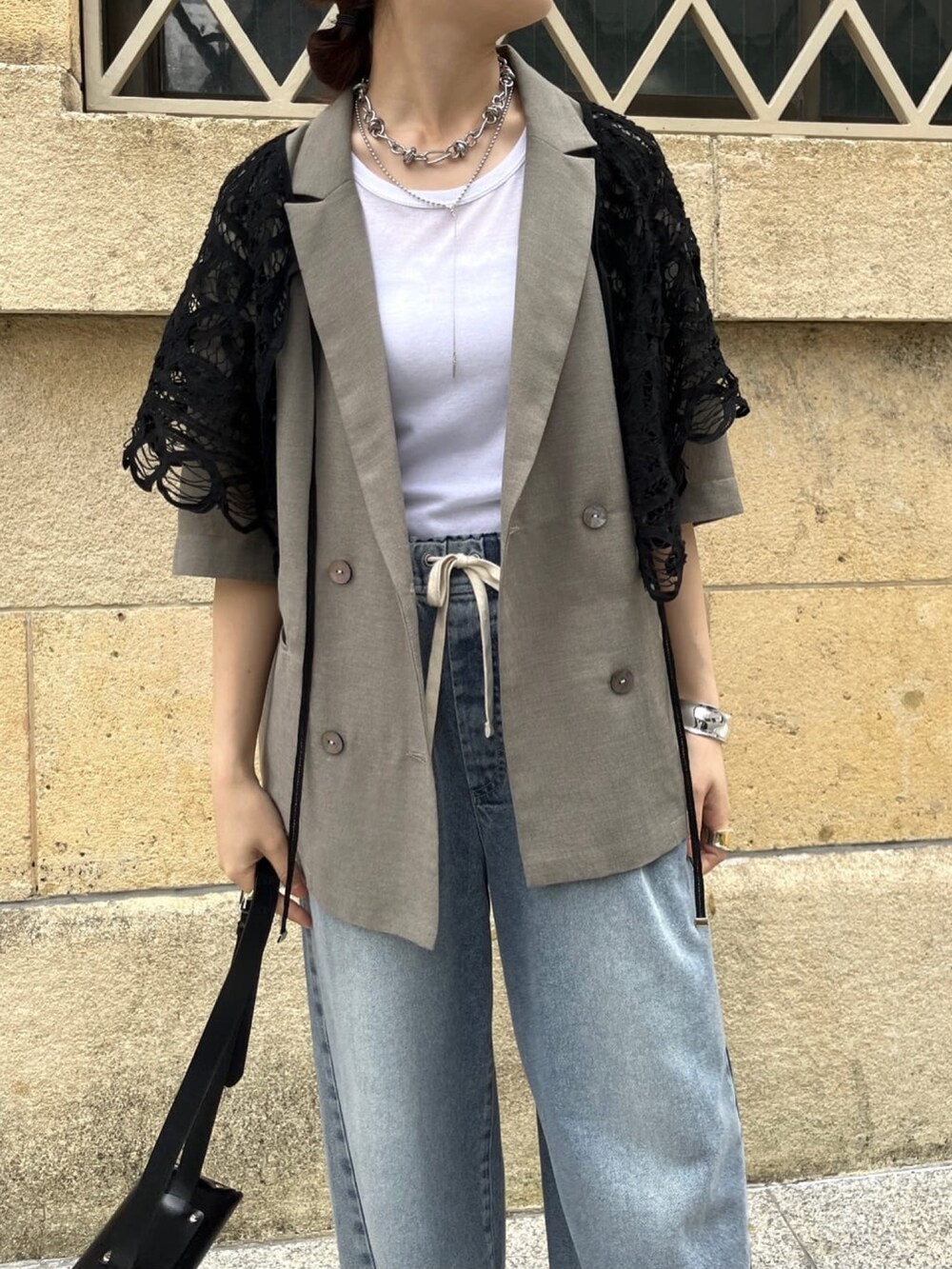 ベージュ系のテーラードジャケット、ブルー系のデニムパンツ、ホワイト系のTシャツ/カットソーを着用したレディースの夏コーディネートの3枚目の写真