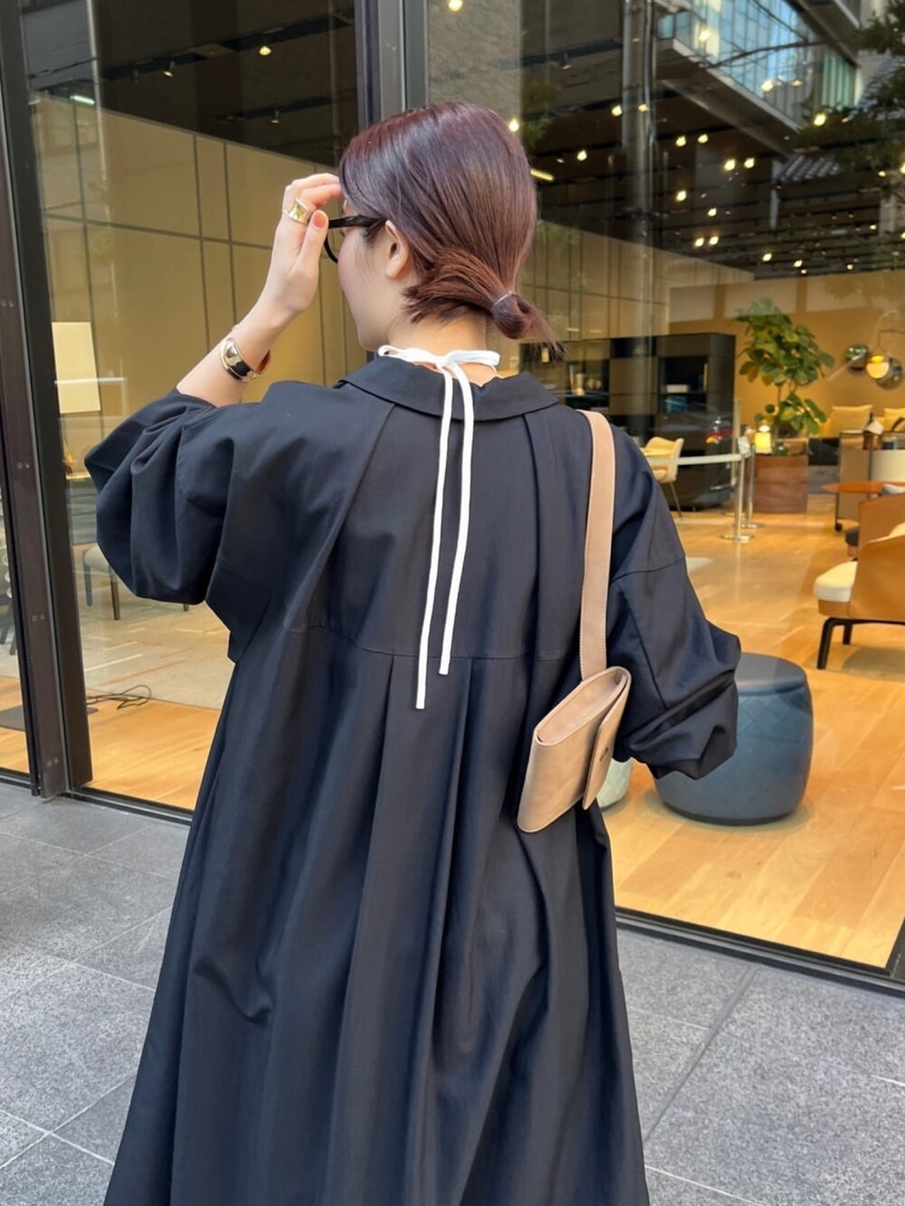 ブラック系のワンピース、ブルー系のデニムパンツ、ホワイト系のキャミソールを着用したレディースの冬コーディネートの4枚目の写真