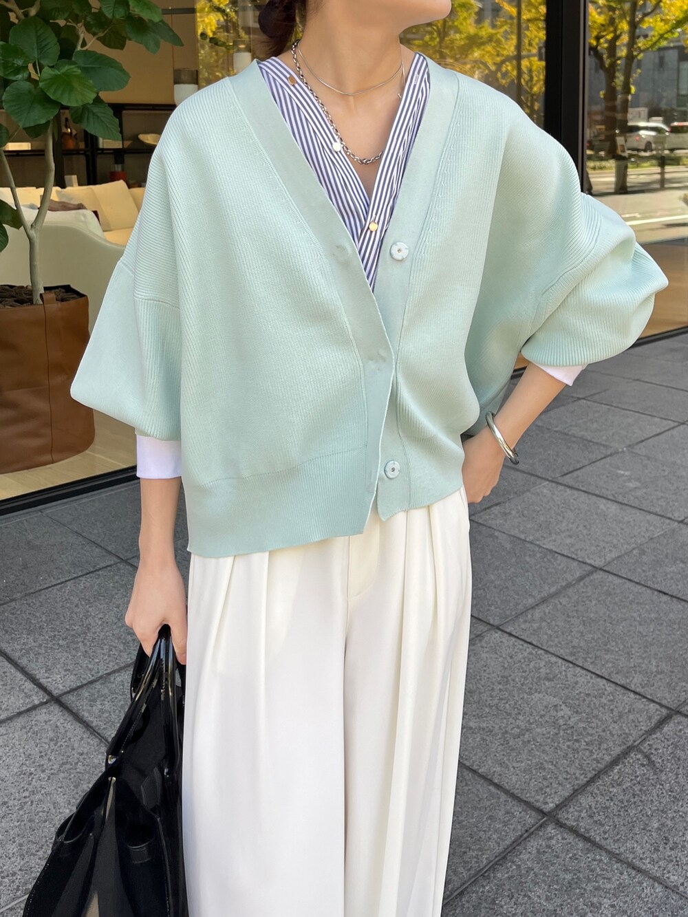 ホワイト系のカーディガン/ボレロ、ホワイト系のスラックスを着用したレディースの冬コーディネートの5枚目の写真