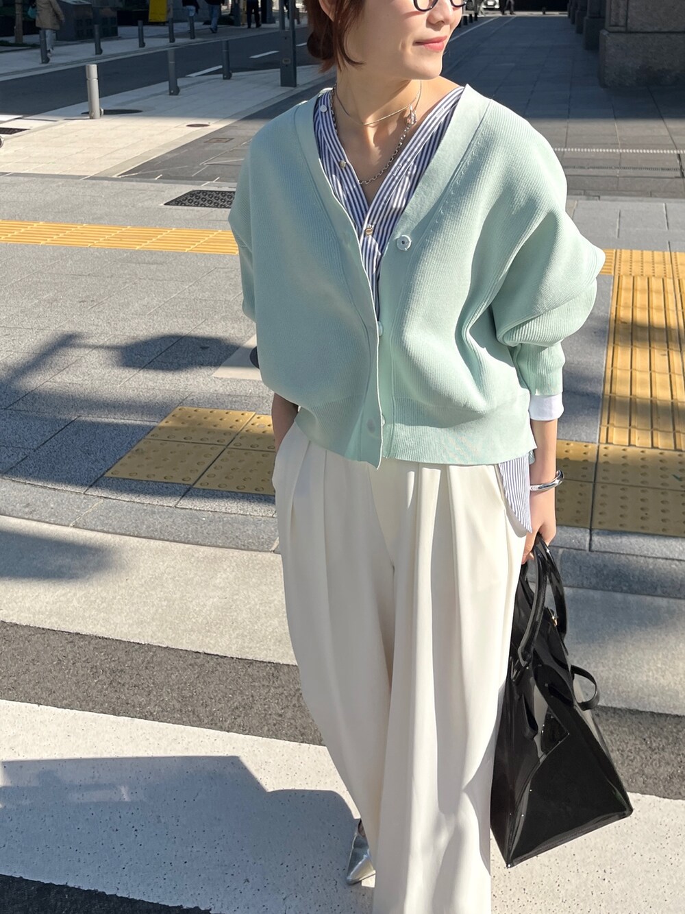 ホワイト系のカーディガン/ボレロ、ホワイト系のスラックスを着用したレディースの冬コーディネートの3枚目の写真