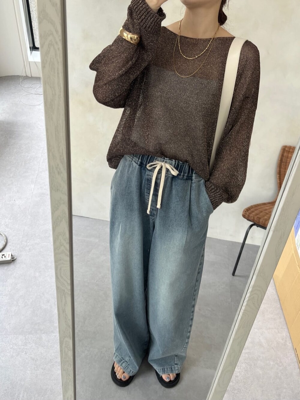 ブラウン系のニット/セーター、ブルー系のデニムパンツ、シルバー系のブーツを着用したレディースの春コーディネートの7枚目の写真