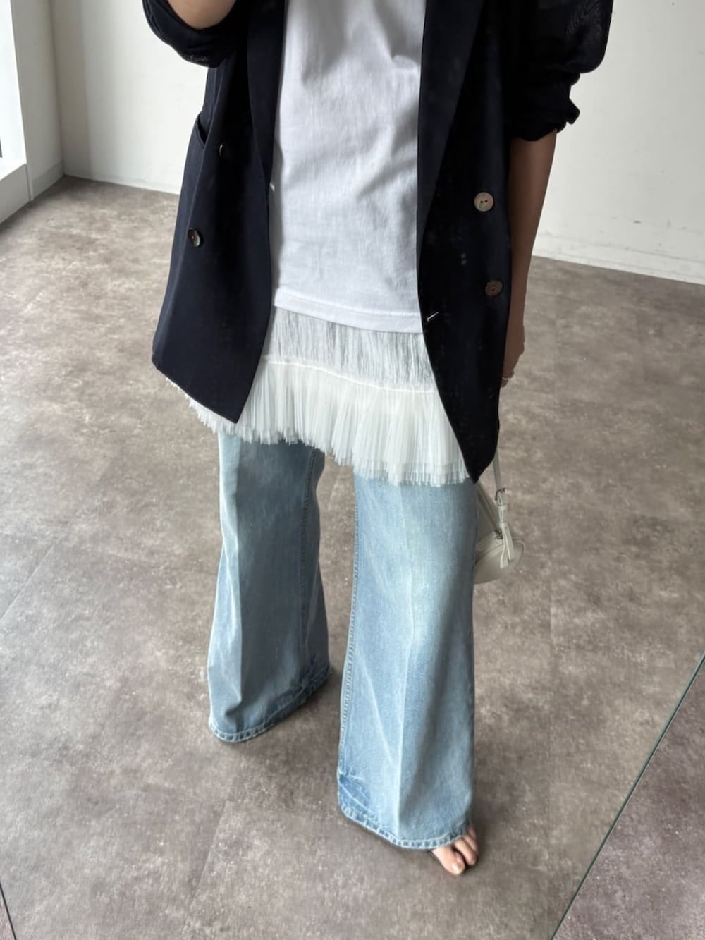 ホワイト系のTシャツ/カットソー、ホワイト系のシャツ/ブラウス、ブルー系のデニムパンツを着用したレディースの春コーディネートの5枚目の写真