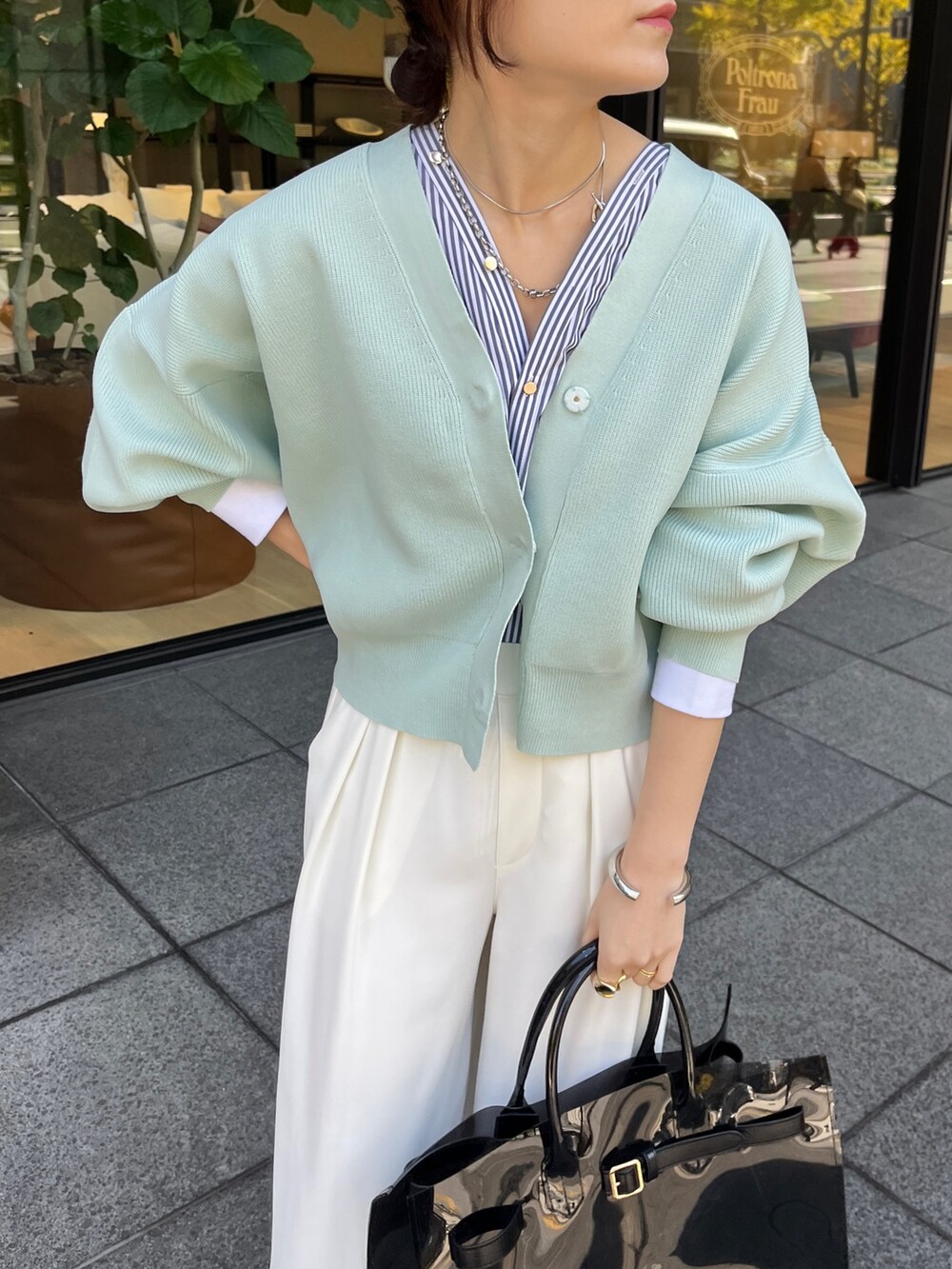 ホワイト系のカーディガン/ボレロ、ホワイト系のスラックスを着用したレディースの冬コーディネートの4枚目の写真