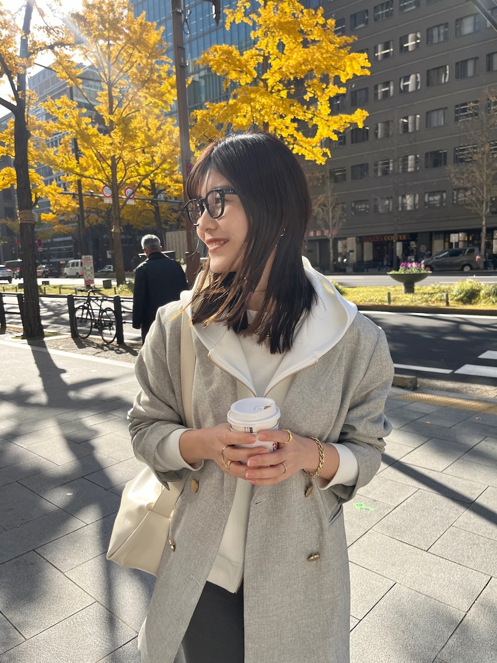 ホワイト系のパーカー、グレー系のテーラードジャケット、グレー系のスカートを着用したレディースの冬コーディネートの5枚目の写真