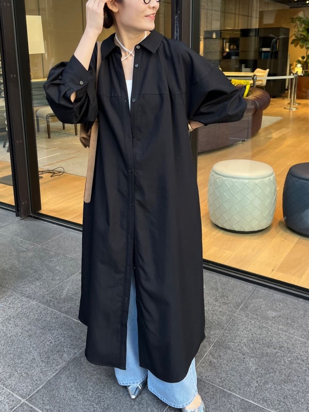 ブラック系のワンピース、ブルー系のデニムパンツ、ホワイト系のキャミソールを着用したレディースの冬コーディネートの6枚目の写真