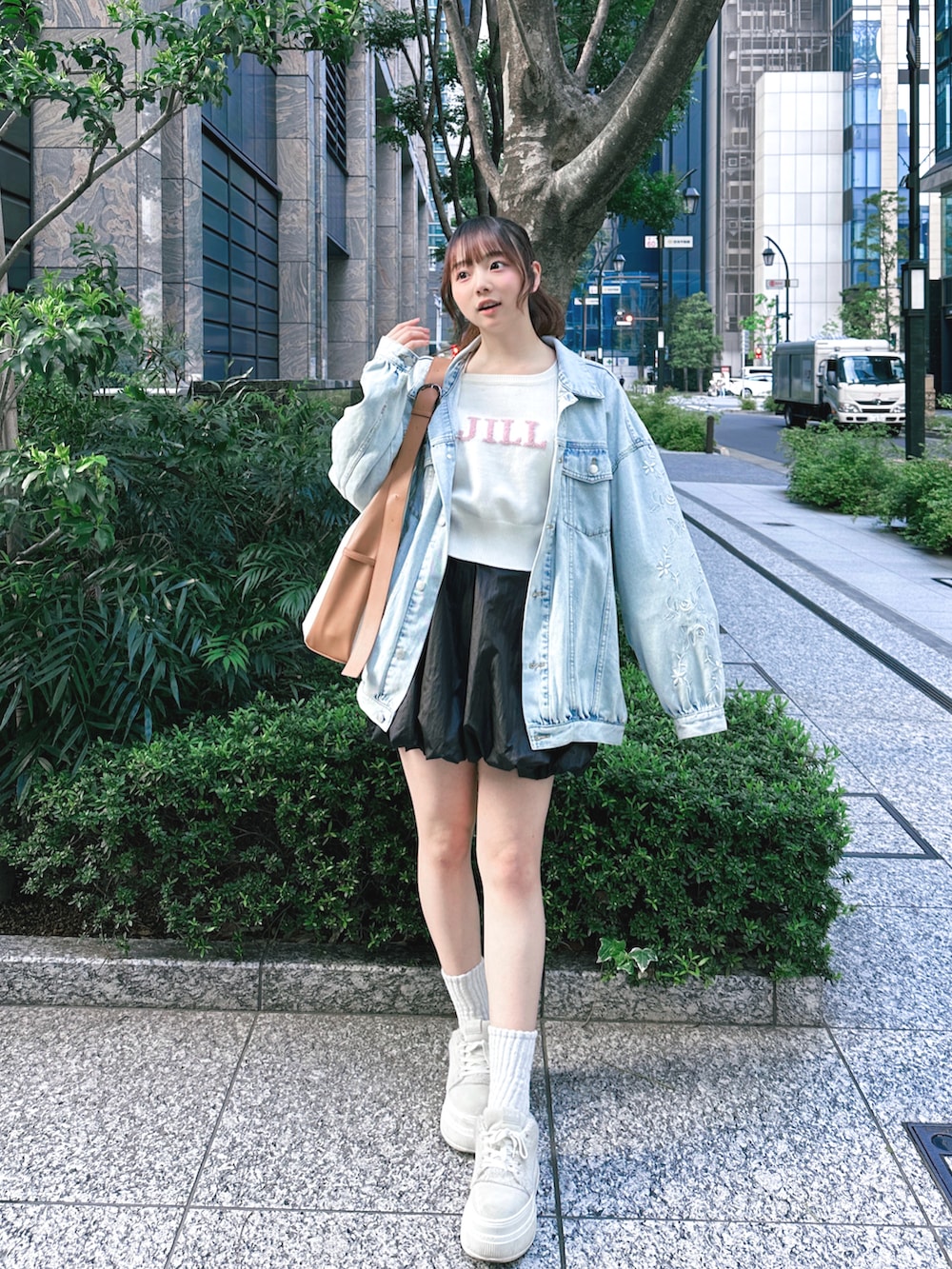 ホワイト系のスニーカー、ブラック系のスカート、ホワイト系のニット/セーターを着用したレディースの春コーディネートの2枚目の写真