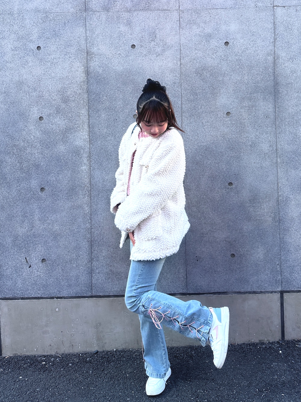 ホワイト系のブルゾン、ブルー系のデニムパンツ、ピンク系のニット/セーターを着用したレディースの冬コーディネートの2枚目の写真