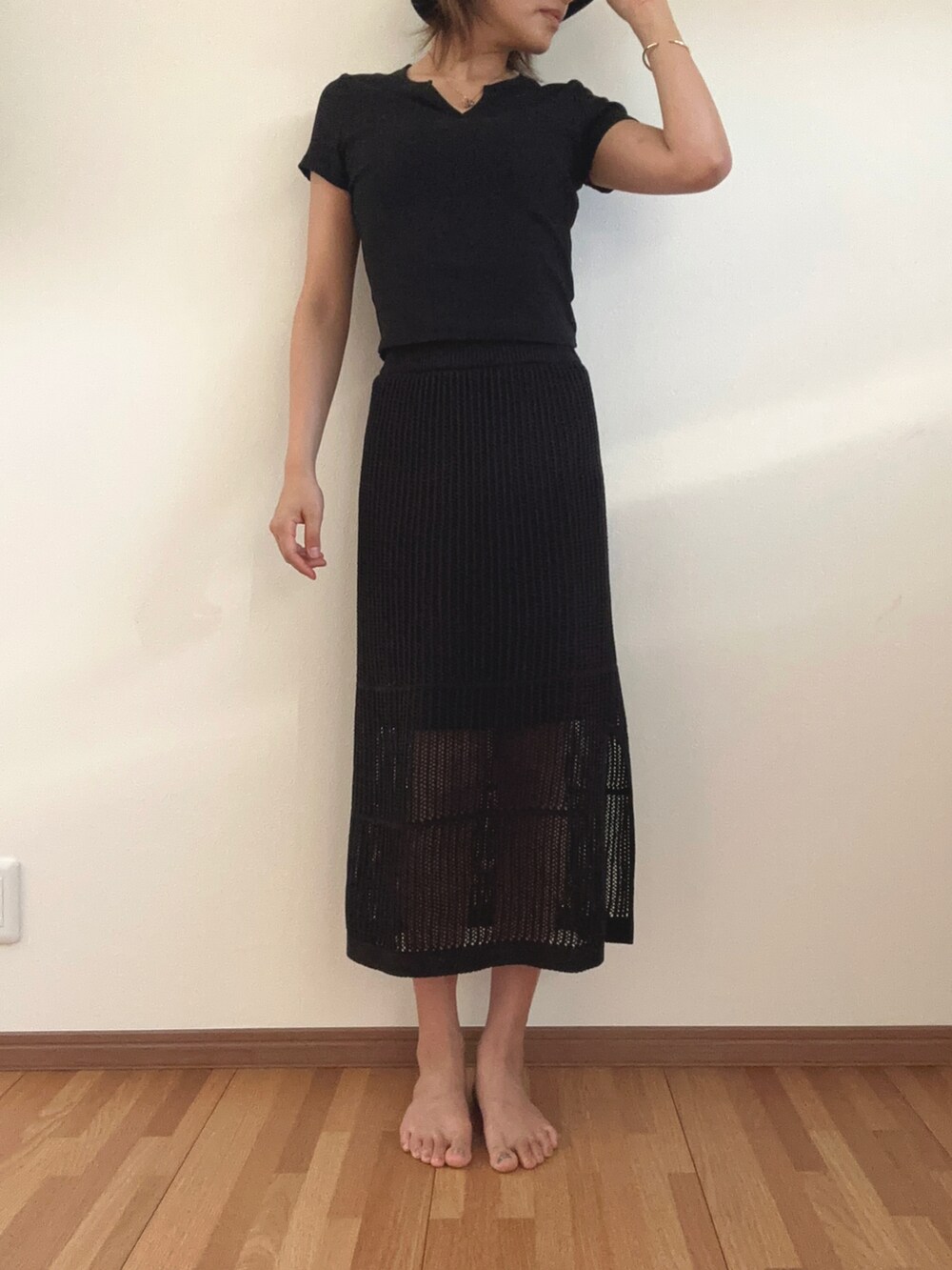 ブラック系のTシャツ/カットソー、ブラック系のスカート、ブラック系のハットを着用したレディースの夏コーディネートの2枚目の写真