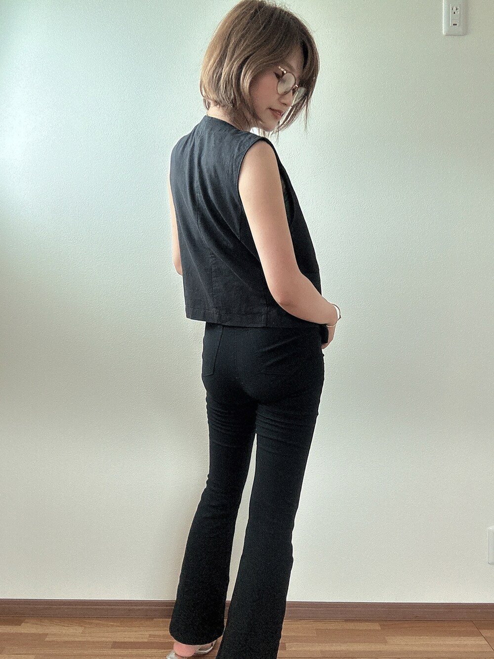 ブラック系のパンツ、ブラック系のベストを着用したレディースの夏コーディネートの2枚目の写真