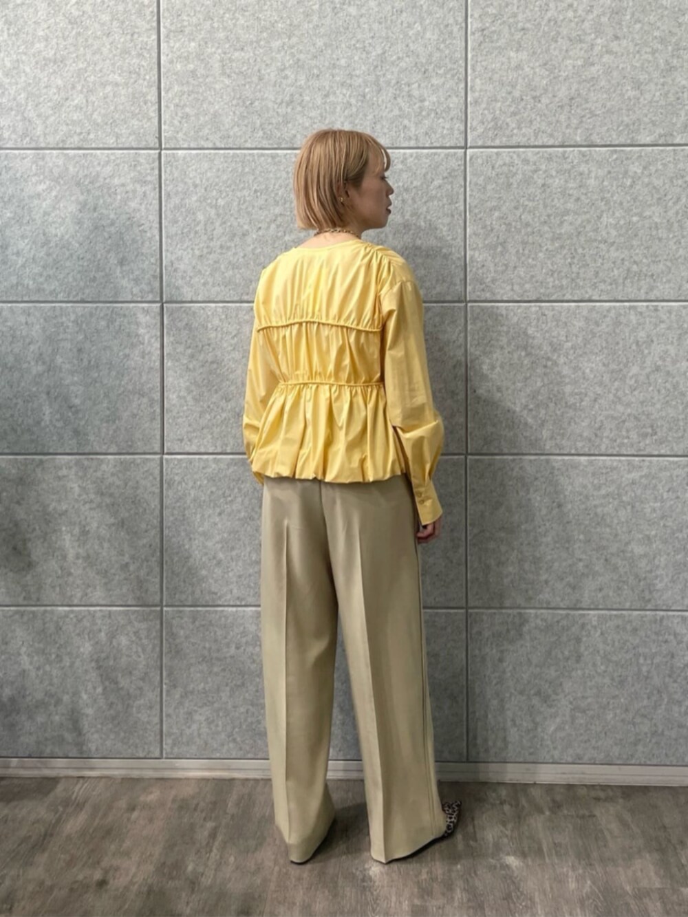 イエロー系のシャツ/ブラウス、ベージュ系のその他パンツを着用したレディースの冬コーディネートの2枚目の写真