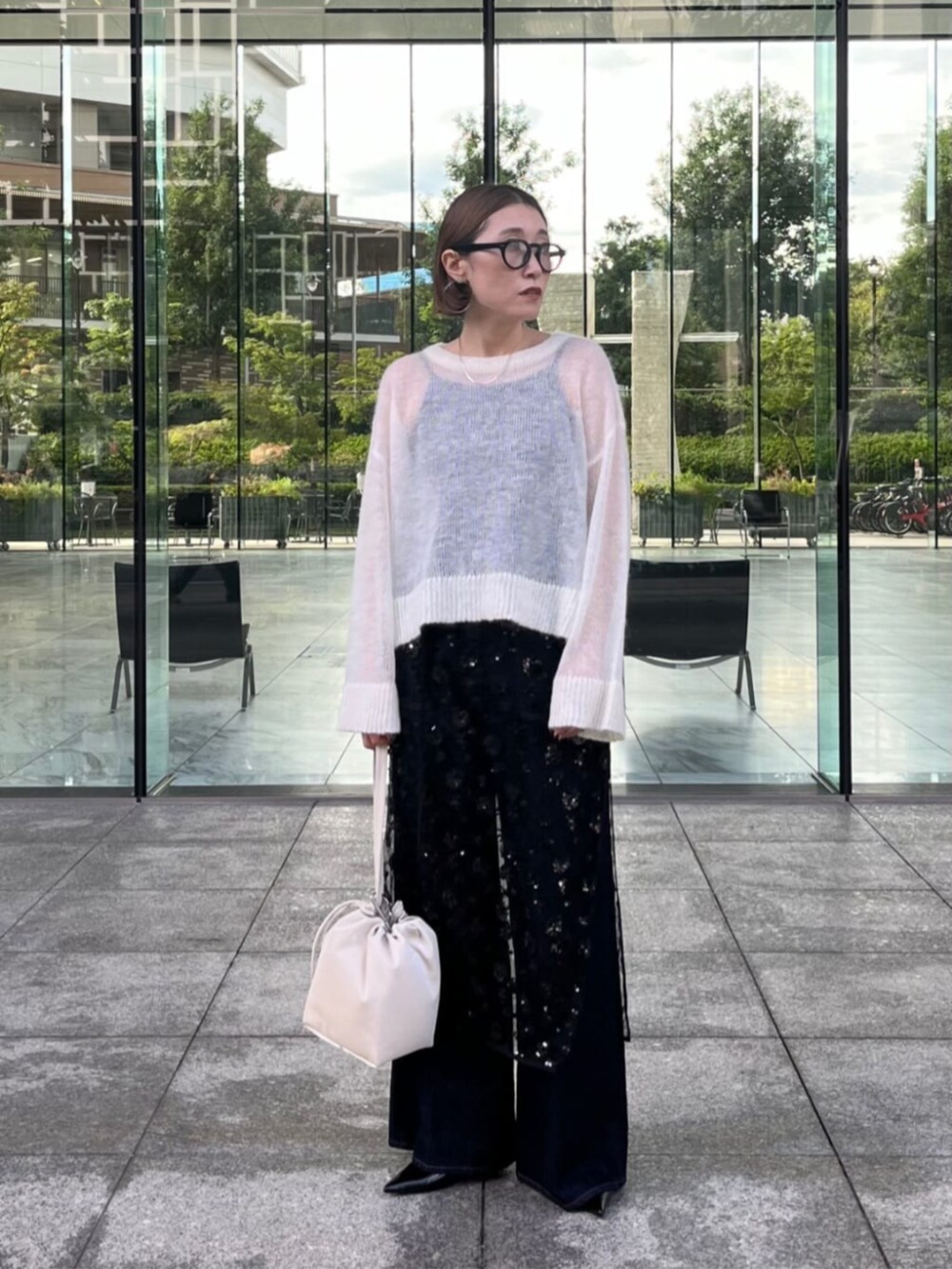 ブラック系のその他パンツ、ブラック系のスカート、ホワイト系のニット/セーターを着用したレディースの秋コーディネートの2枚目の写真