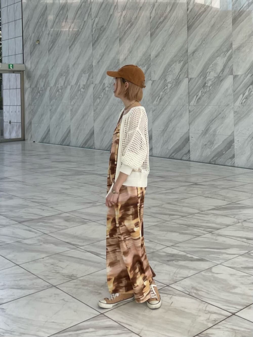 イエロー系のワンピース、ホワイト系のカーディガン/ボレロを着用したレディースの春コーディネートの4枚目の写真