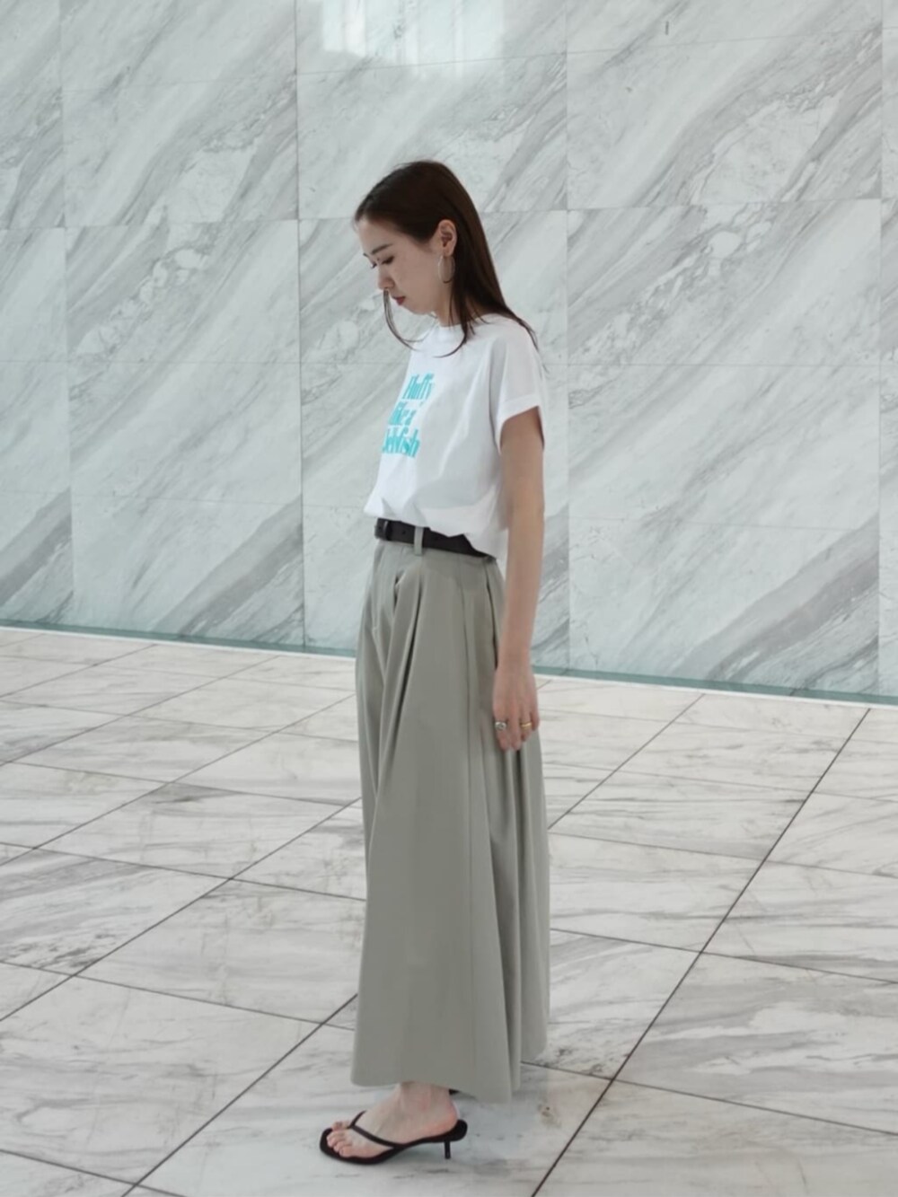 グリーン系のスカート、ホワイト系のTシャツ/カットソーを着用したレディースの春コーディネートの2枚目の写真