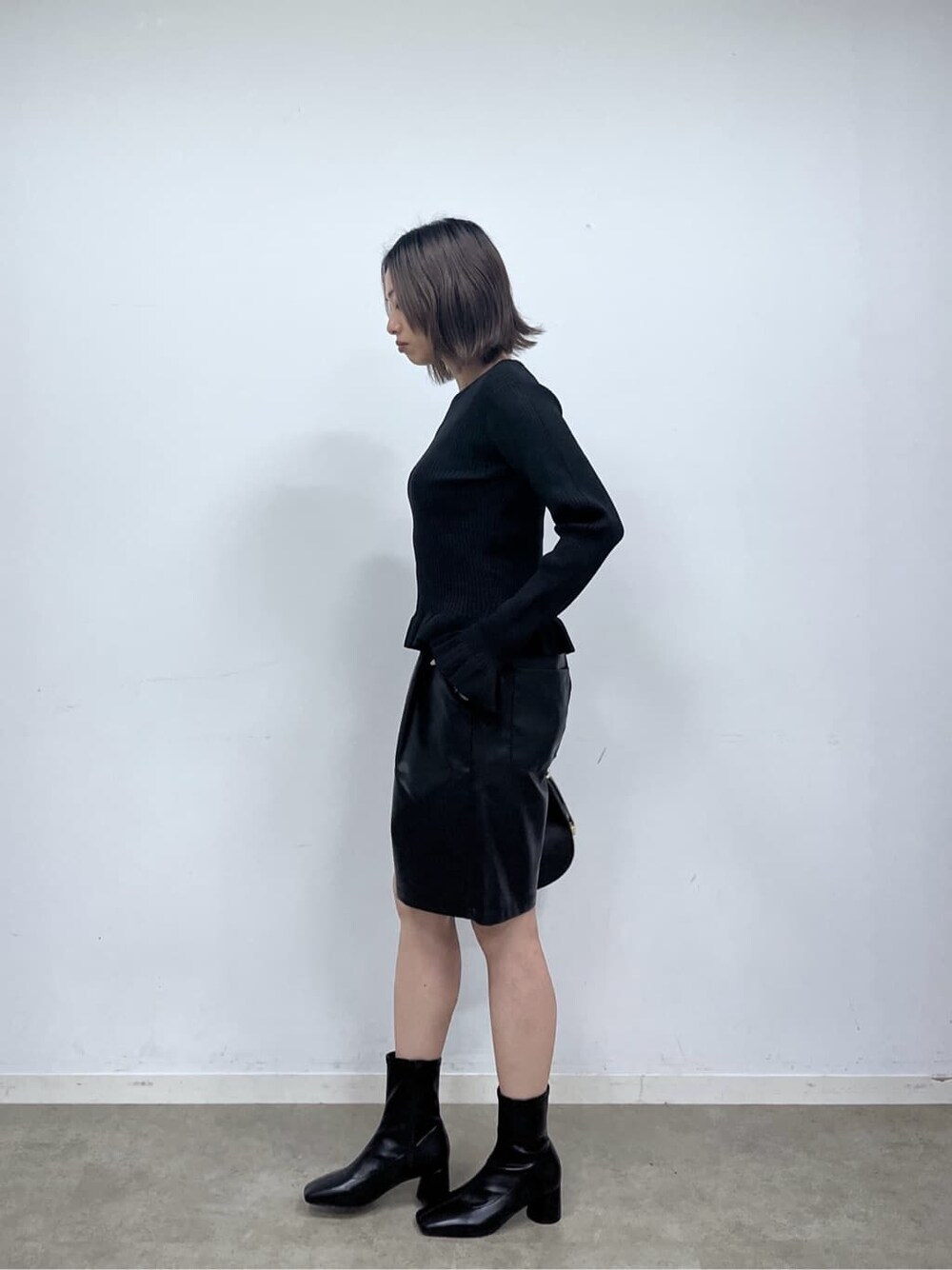 ブラック系のニット/セーター、ブラック系のその他パンツ、ブラック系のハンドバッグを着用したレディースの秋コーディネートの4枚目の写真