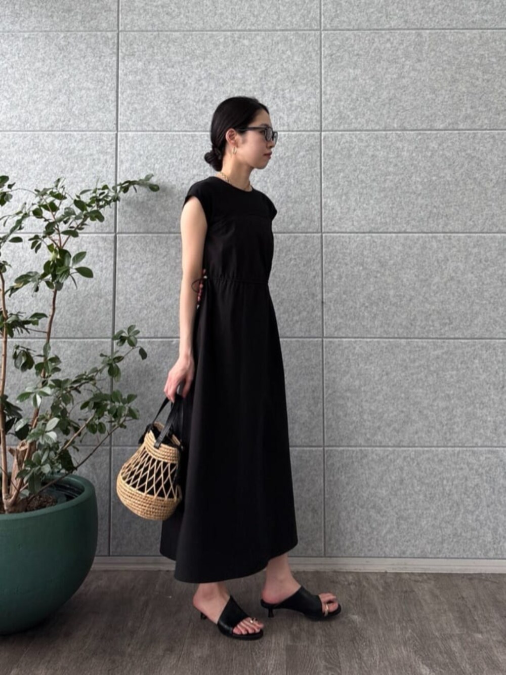 ブラック系のワンピースを着用したレディースの夏コーディネートの2枚目の写真