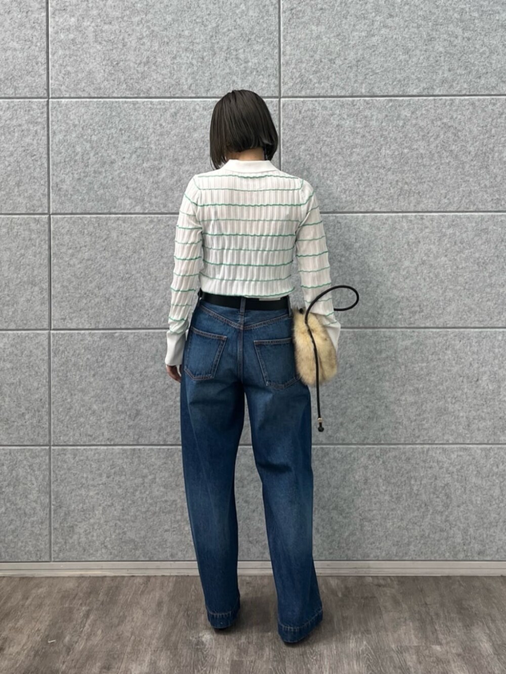 ブルー系のデニムパンツ、ホワイト系のニット/セーターを着用したレディースの冬コーディネートの2枚目の写真