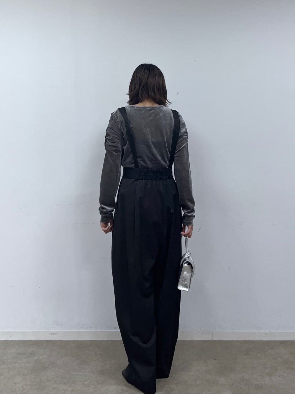 ブラック系のサロペット/オーバーオール、グレー系のTシャツ/カットソー、シルバー系のハンドバッグを着用したレディースの秋コーディネートの5枚目の写真