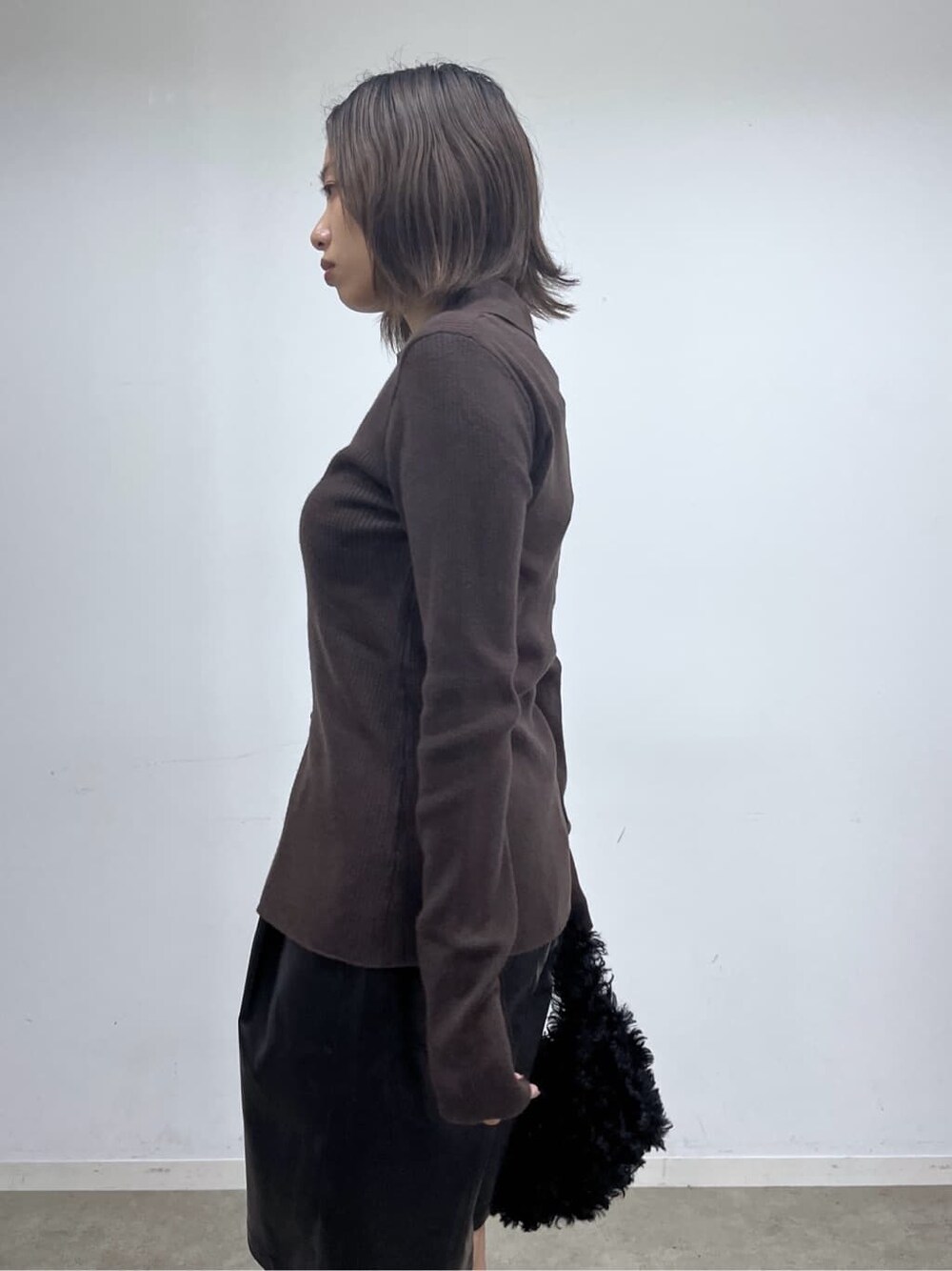 ブラウン系のニット/セーター、ブラック系のその他パンツ、ブラック系のブーツを着用したレディースの秋コーディネートの8枚目の写真