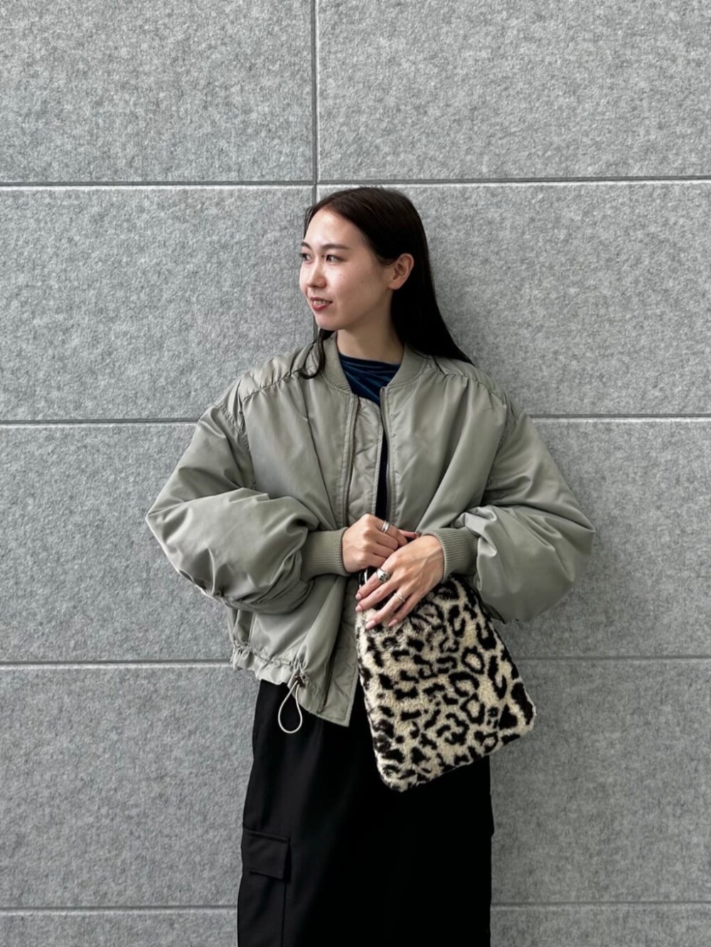 ブラウン系のハンドバッグ、ブラック系のスカート、ブルー系のTシャツ/カットソーを着用したレディースの秋コーディネートの4枚目の写真