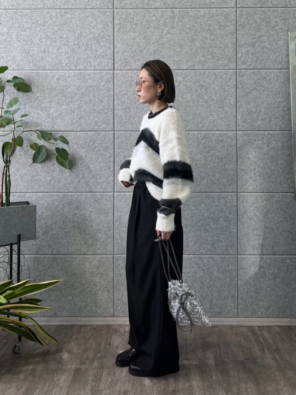 シルバー系のショルダーバッグ、グレー系のニット/セーター、ブラック系のその他パンツを着用したレディースの冬コーディネートの3枚目の写真