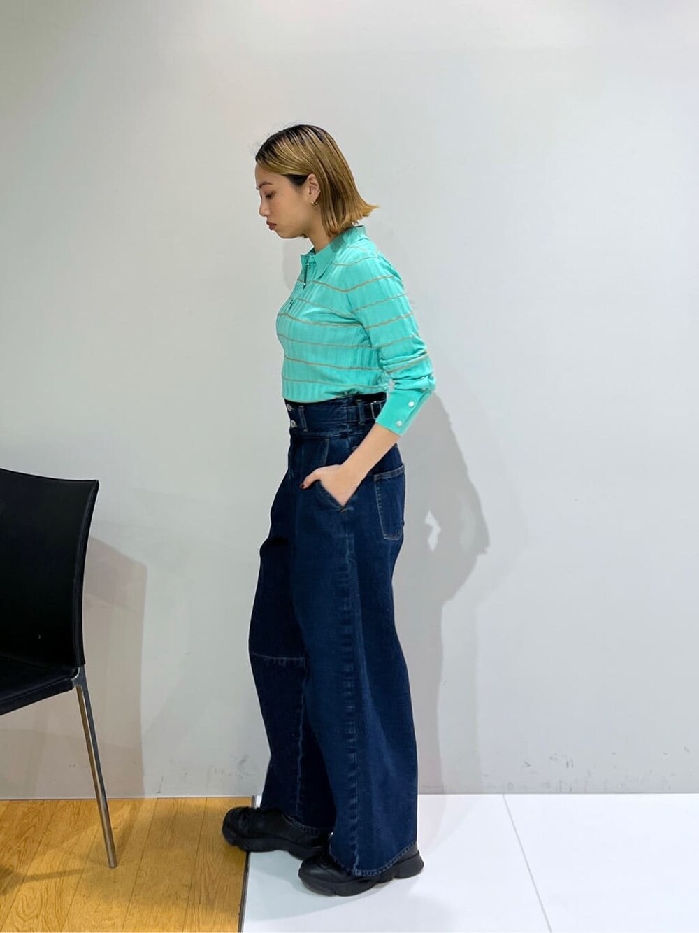 グリーン系のニット/セーター、ブルー系のデニムパンツを着用したレディースの冬コーディネートの2枚目の写真