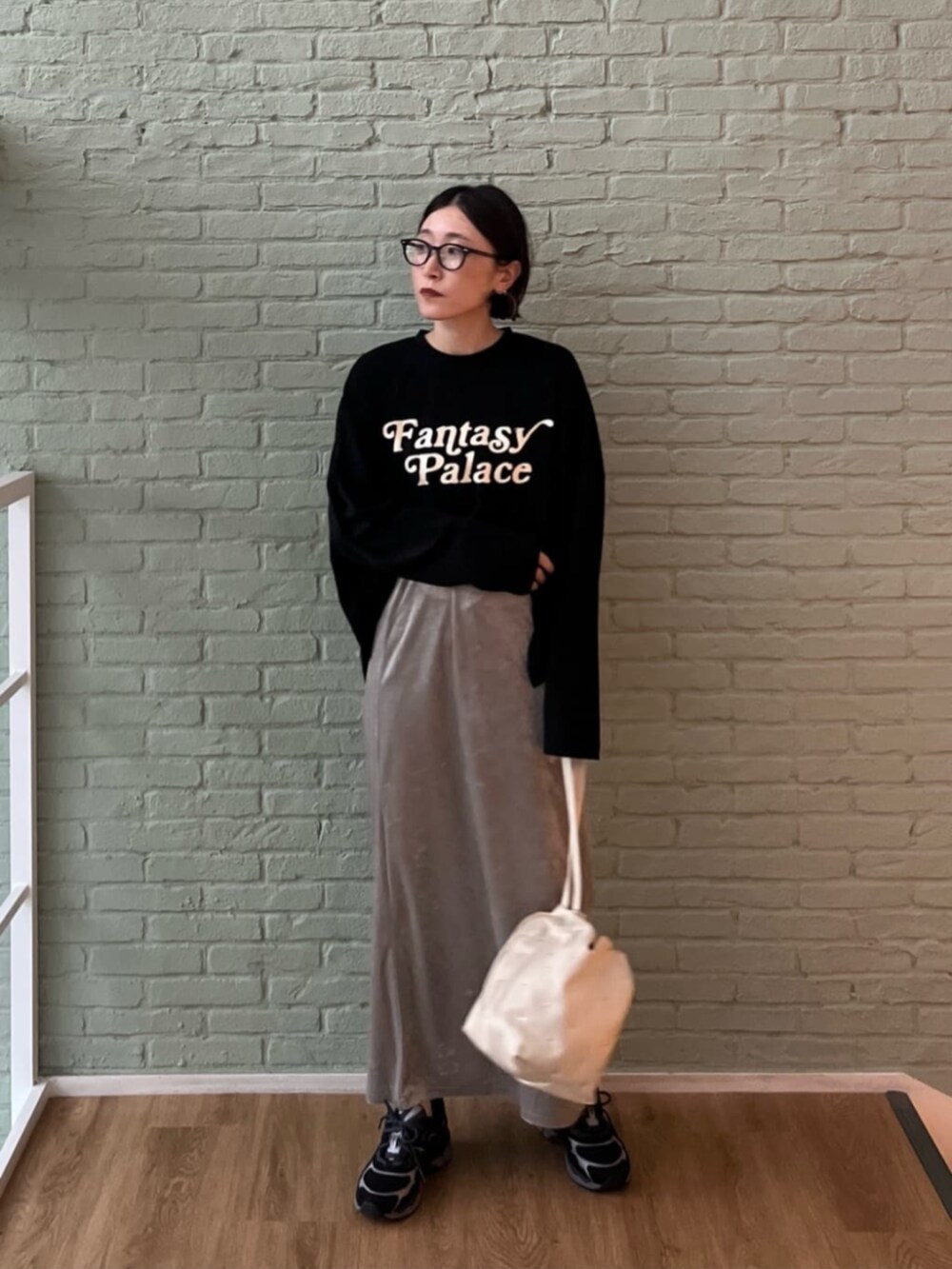 シルバー系のスカート、ブラック系のTシャツ/カットソー、ホワイト系のハンドバッグを着用したレディースの秋コーディネートの3枚目の写真