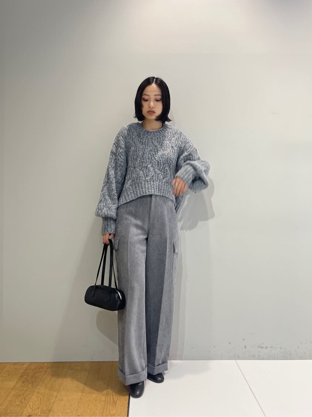 グレー系のニット/セーター、グレー系のその他パンツ、ブラック系のハンドバッグを着用したレディースの秋コーディネートの2枚目の写真